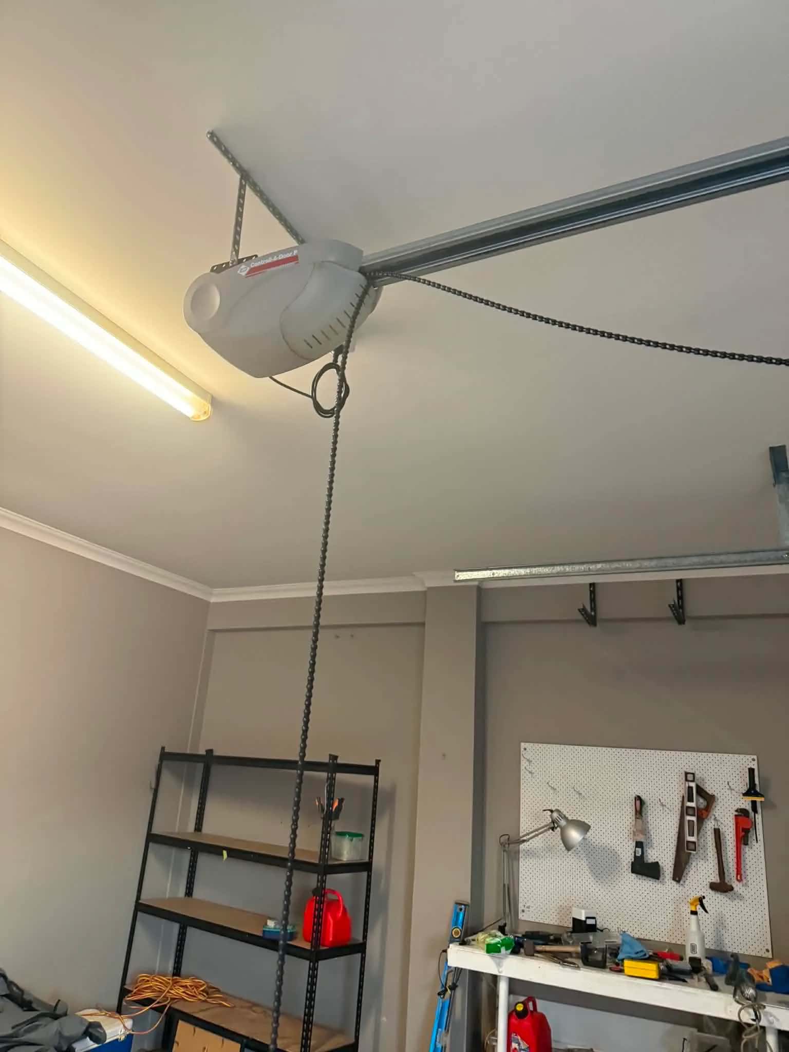 Technician programming a replacement garage door remote to a newly installed opener in Perth