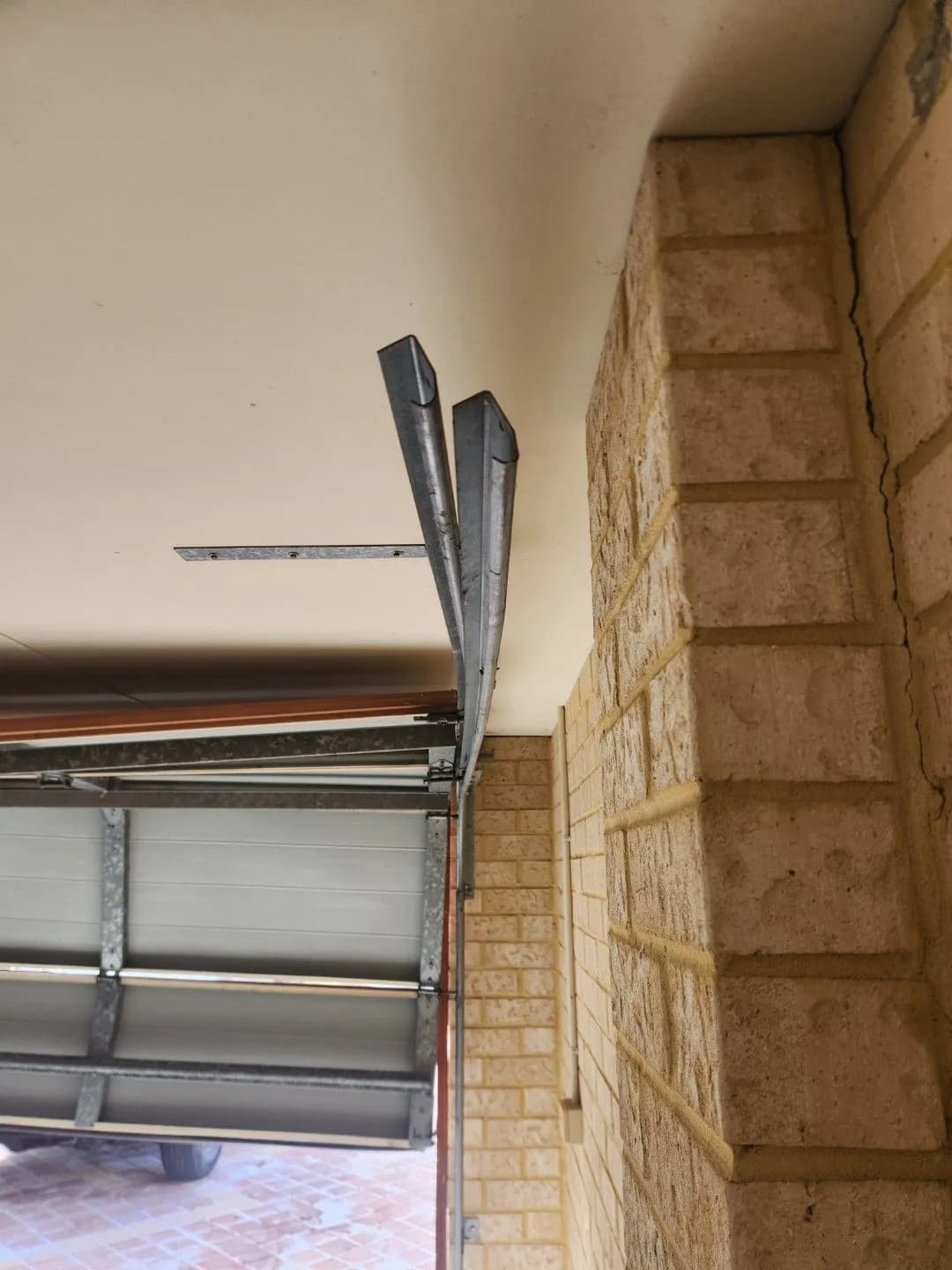 Bent horizontal garage door track above the door opening in Bennett Springs, Perth after a vehicle impact Bent horizontal garage door track above the door opening in Bennett Springs, Perth after a vehicle impact
