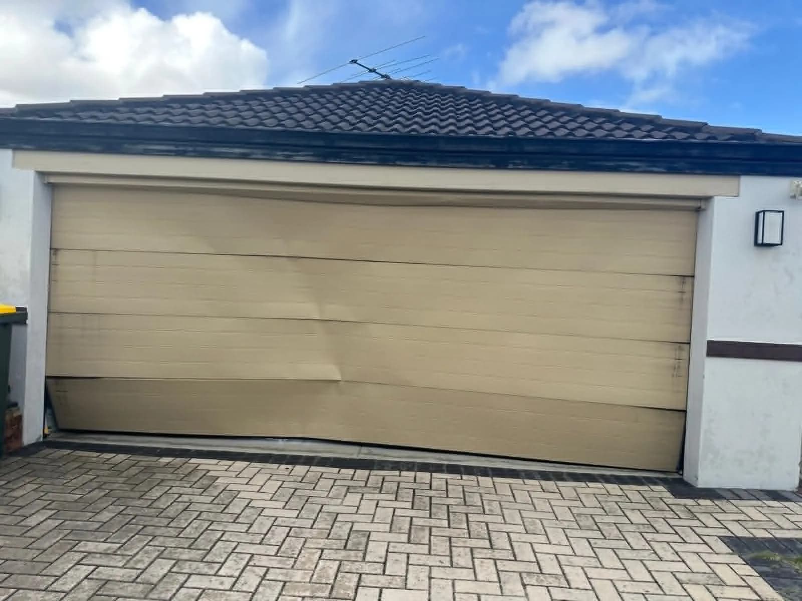 Buckled garage door panel being replaced on a sectional door in Perth Buckled garage door panel being replaced on a sectional door in Perth