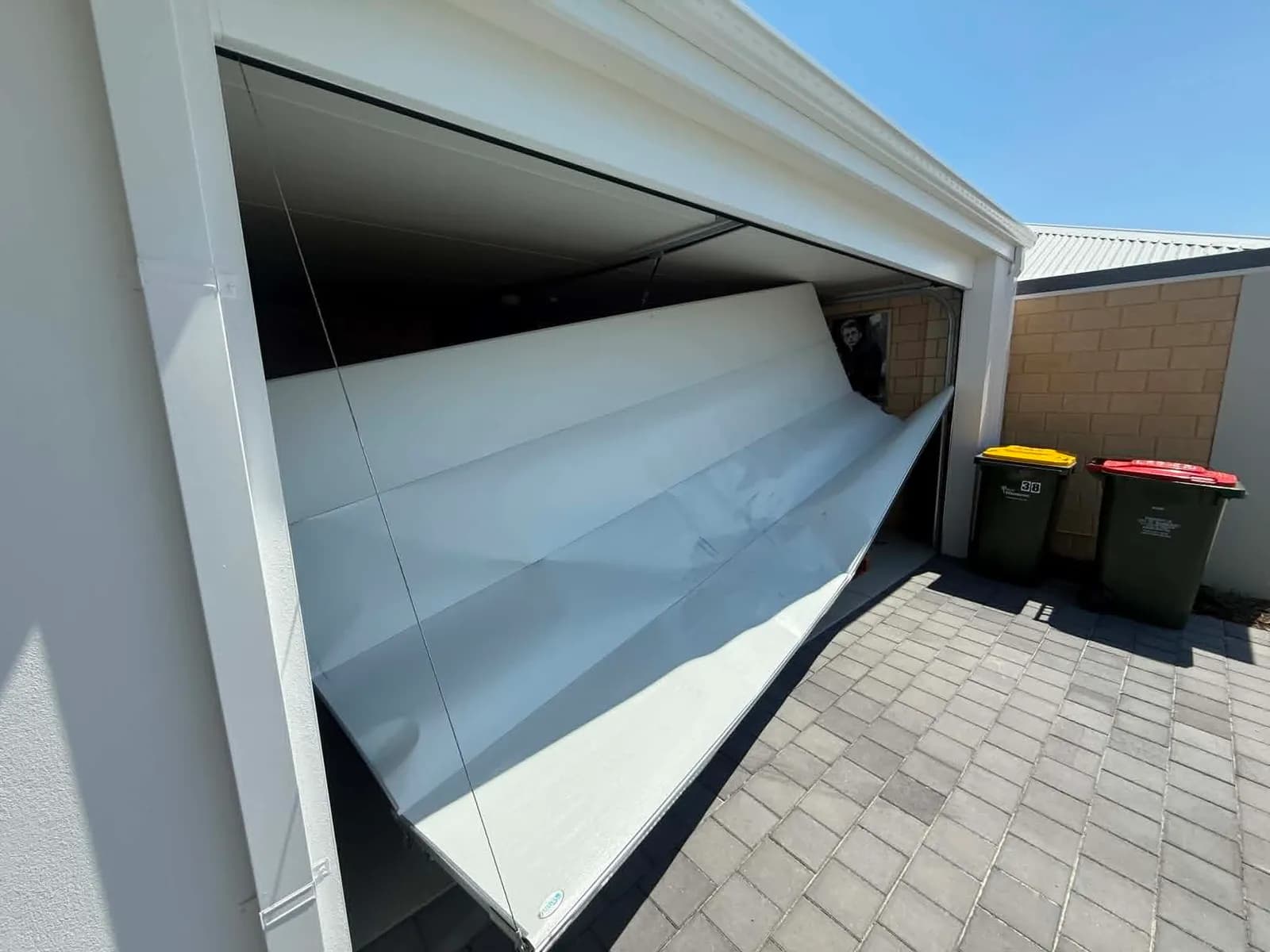 White sectional garage door buckled and hanging out of its tracks in Southern River White sectional garage door buckled and hanging out of its tracks in Southern River