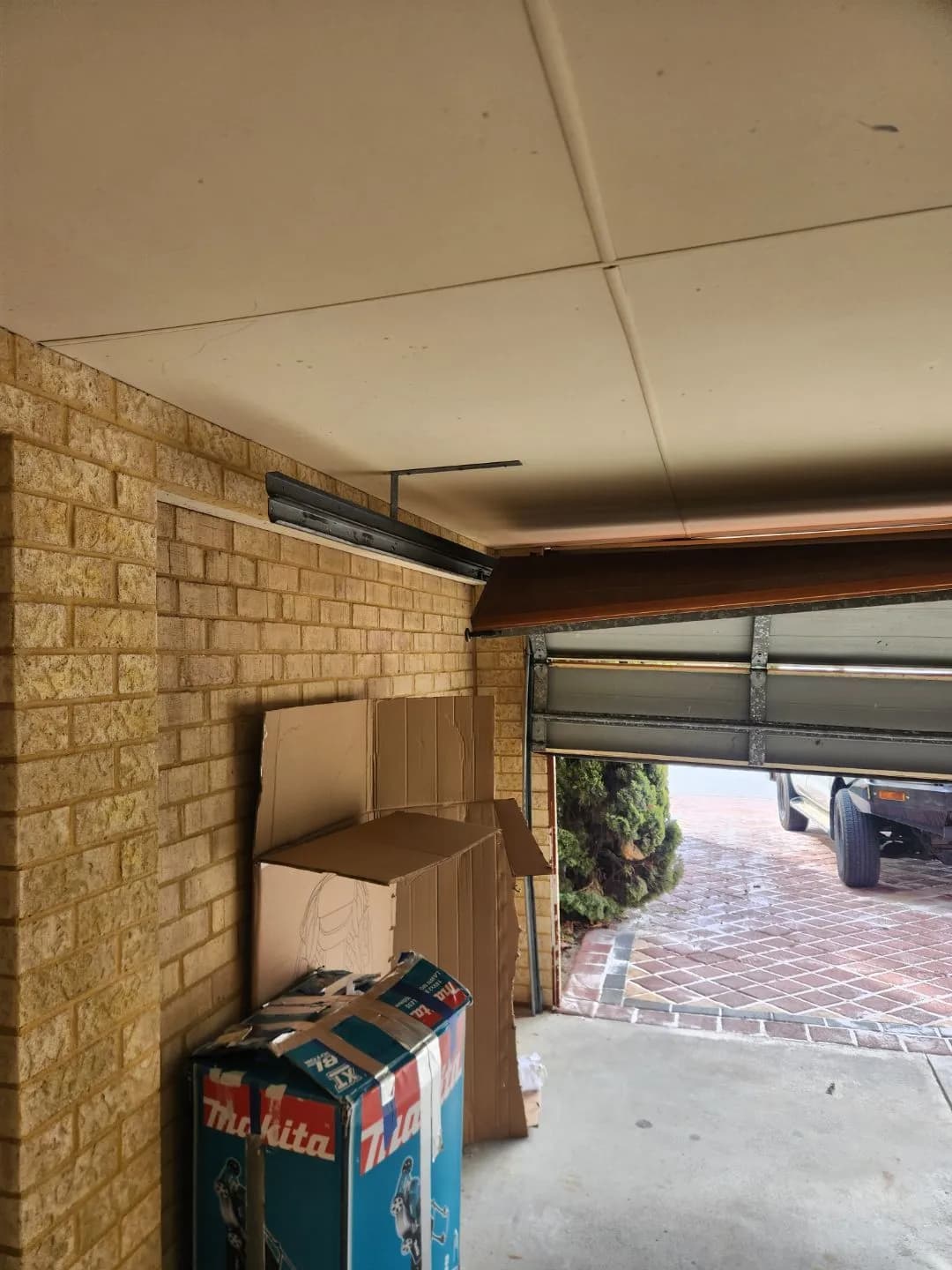Sectional garage door in Bennett Springs, Perth hanging skewed in the opening with its rollers knocked out of the track after a car impact Sectional garage door in Bennett Springs, Perth hanging skewed in the opening with its rollers knocked out of the track after a car impact