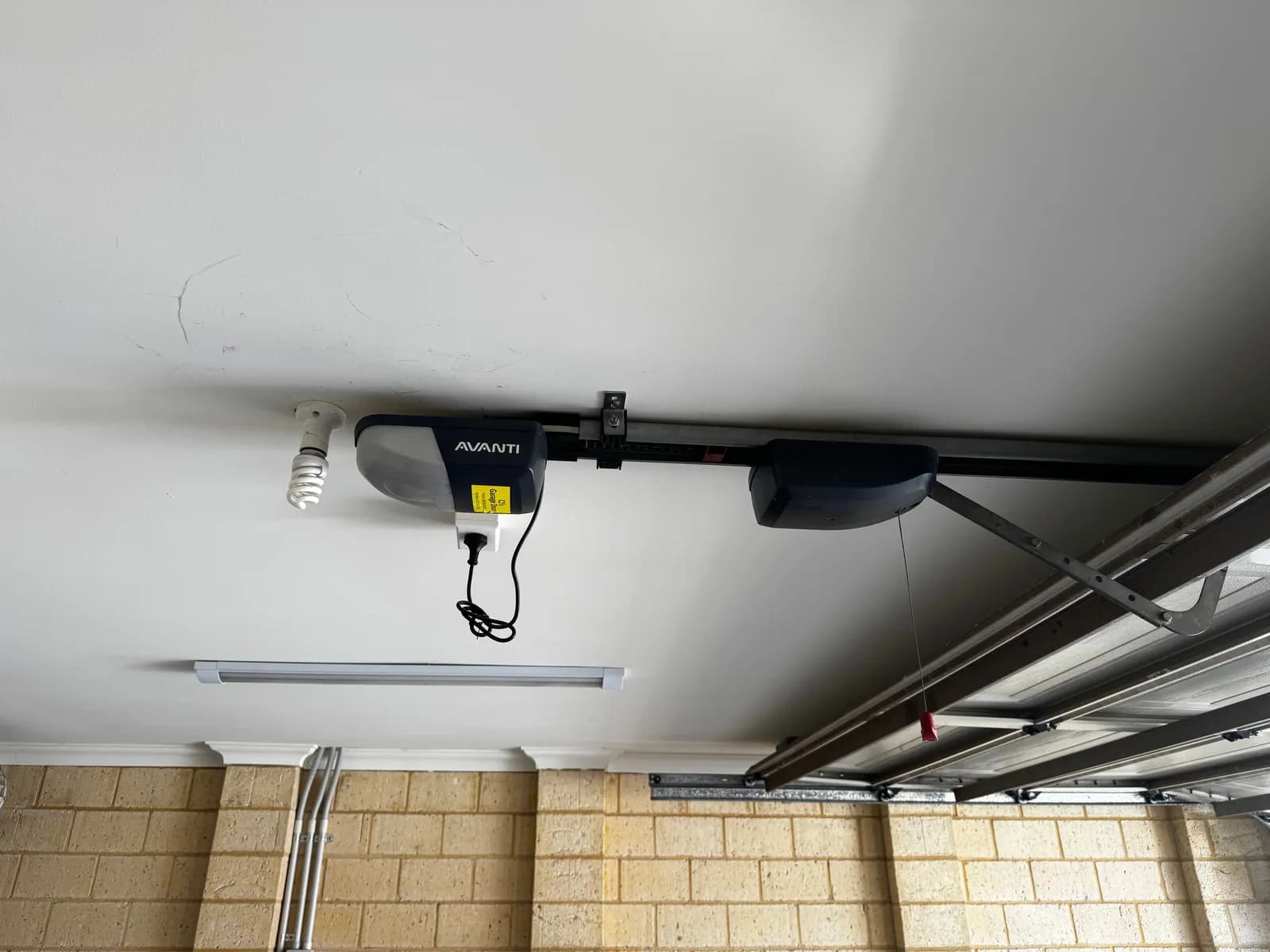 Old Avanti garage door opener mounted on the ceiling rail above a sectional door in Belmont, Perth before replacement Old Avanti garage door opener mounted on the ceiling rail above a sectional door in Belmont, Perth before replacement
