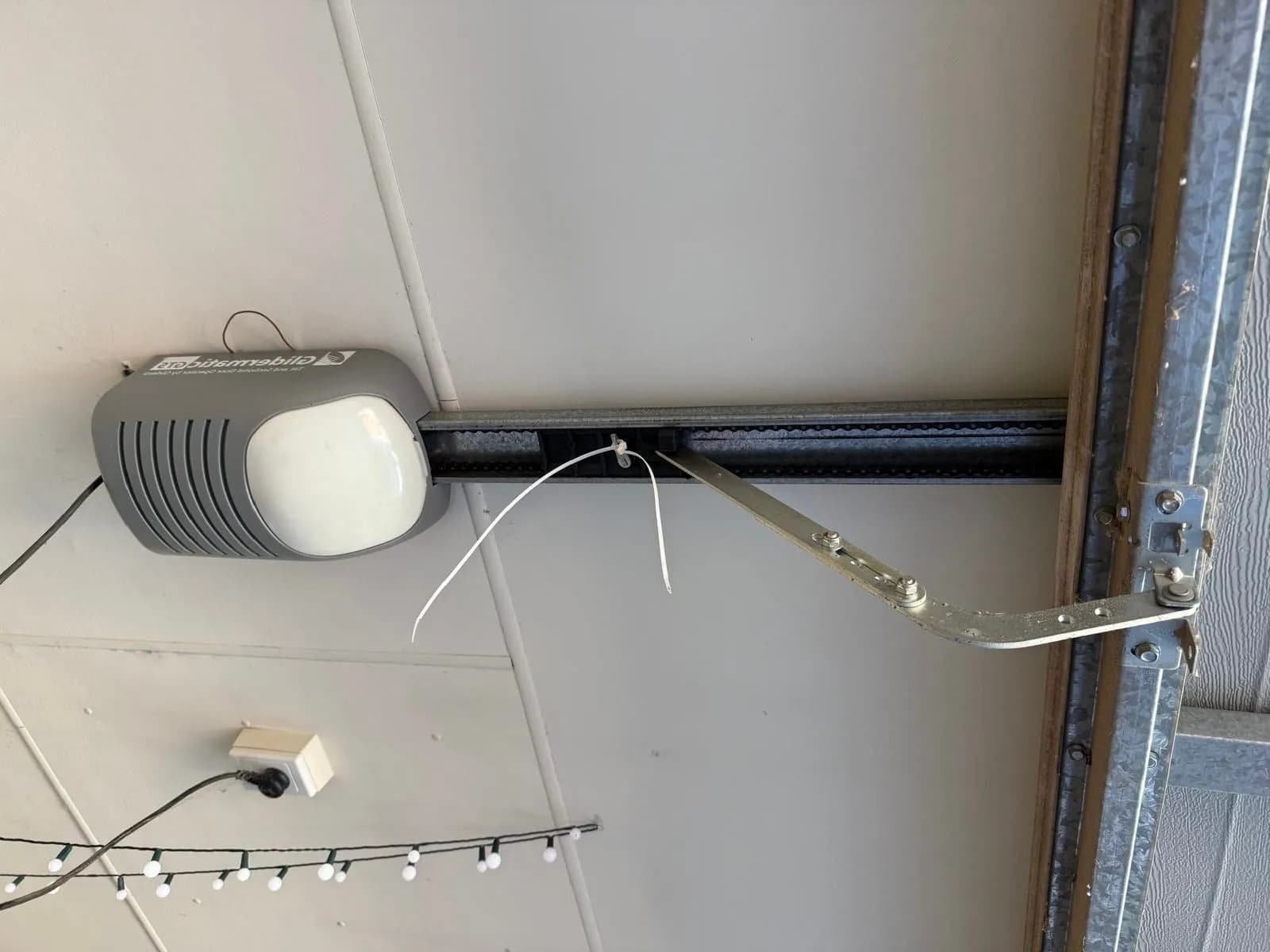 Old grey Gliderol Glidermatic garage door opener on the ceiling rail of a sectional door in Aveley, Perth before replacement Old grey Gliderol Glidermatic garage door opener on the ceiling rail of a sectional door in Aveley, Perth before replacement