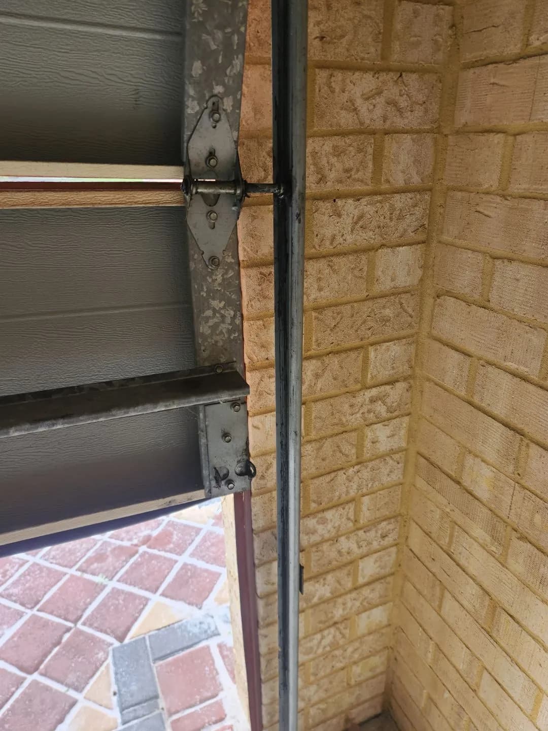 Close-up of a sectional garage door hinge and roller popped out of the vertical track in Bennett Springs, Perth Close-up of a sectional garage door hinge and roller popped out of the vertical track in Bennett Springs, Perth