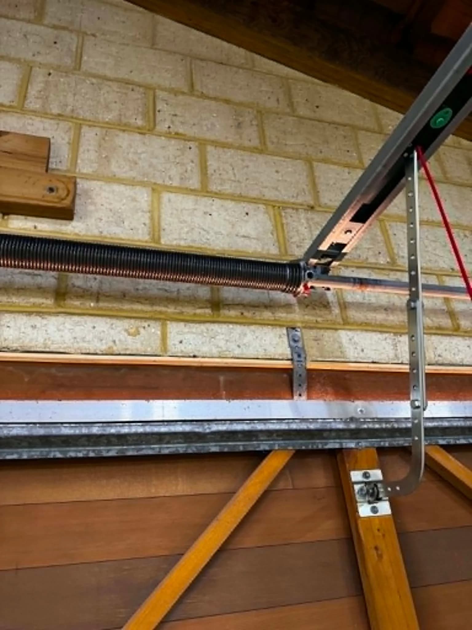 Newly fitted torsion spring on the shaft above a Rockingham garage door Newly fitted torsion spring on the shaft above a Rockingham garage door