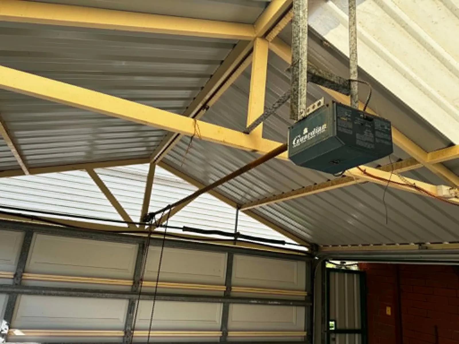 Old Guardian chain-drive garage door opener on the ceiling of a garage in Kingsley, Perth Old Guardian chain-drive garage door opener on the ceiling of a garage in Kingsley, Perth