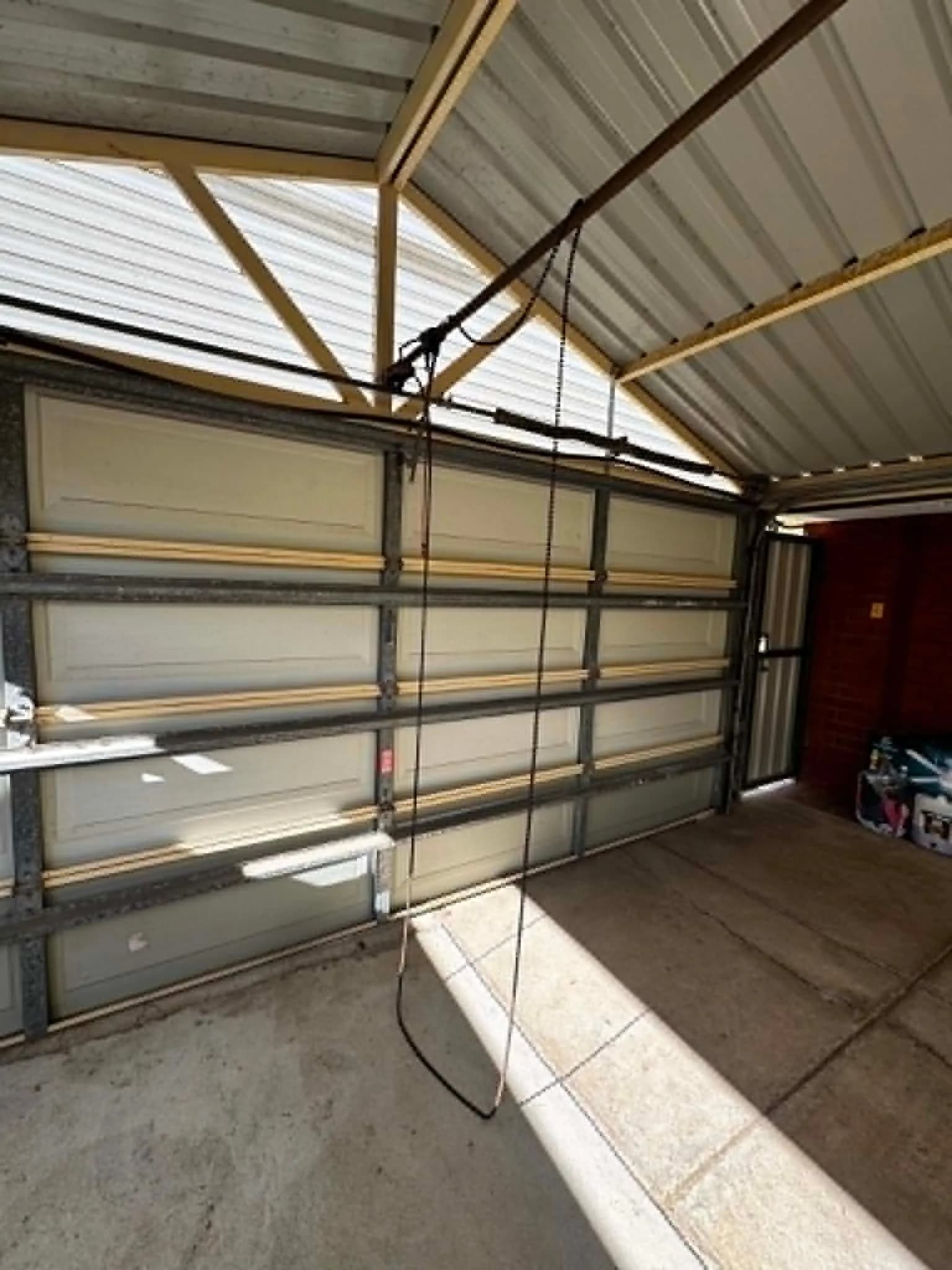 Sectional garage door in Kingsley, Perth stranded with a broken opener chain above it Sectional garage door in Kingsley, Perth stranded with a broken opener chain above it