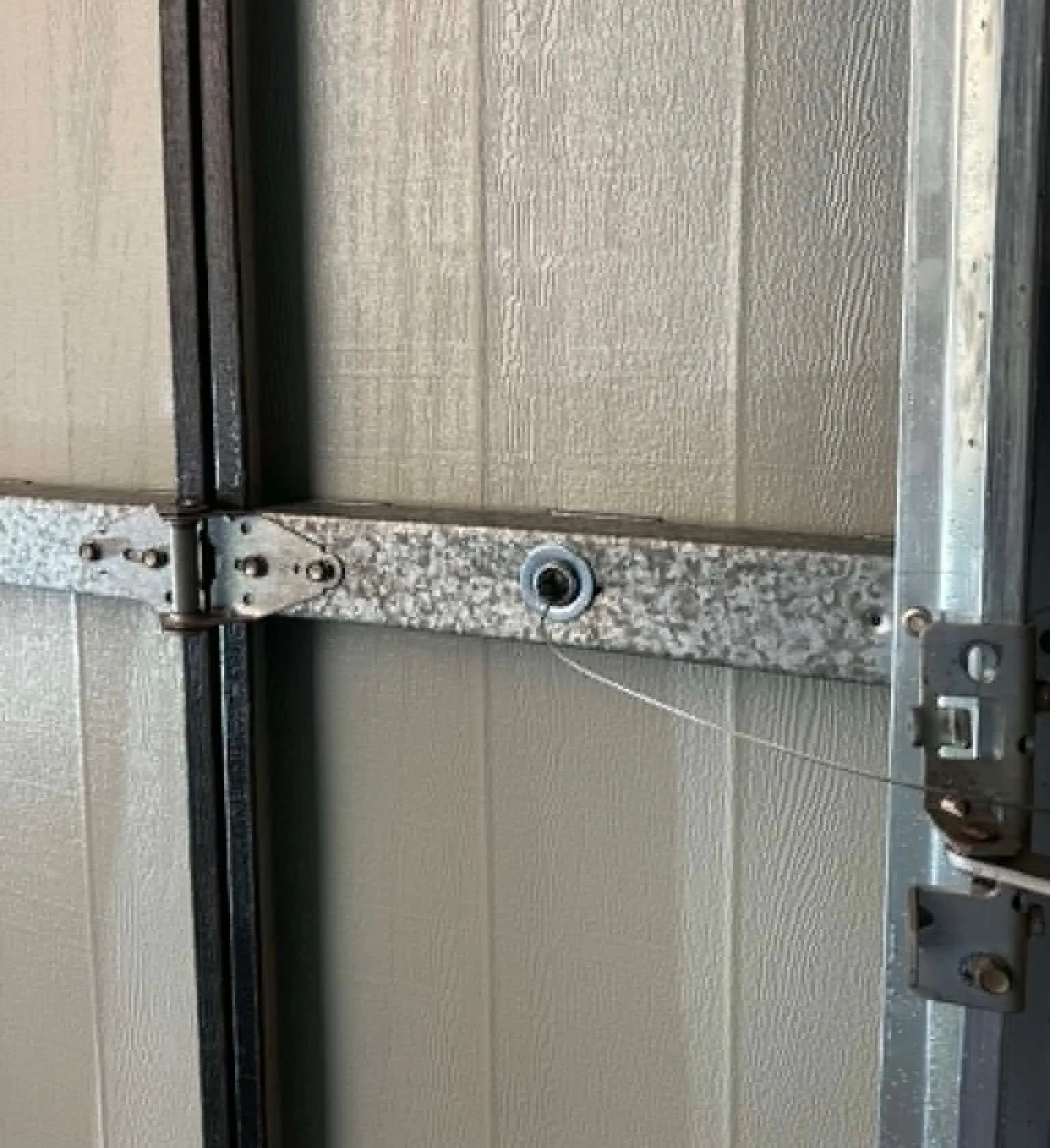 Loose, frayed lift cable hanging at a worn bottom bracket on a Centurion sectional garage door in Forrestfield, Perth Loose, frayed lift cable hanging at a worn bottom bracket on a Centurion sectional garage door in Forrestfield, Perth