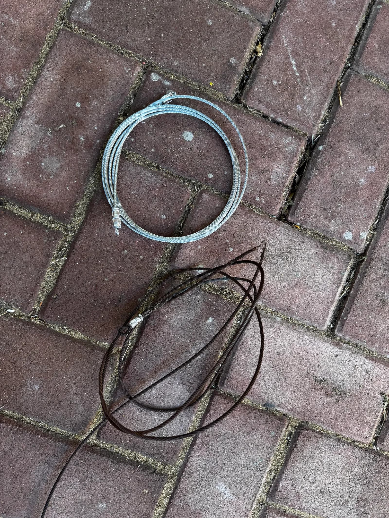 New galvanised lift cable coiled beside the old snapped, corroded cable New galvanised lift cable coiled beside the old snapped, corroded cable