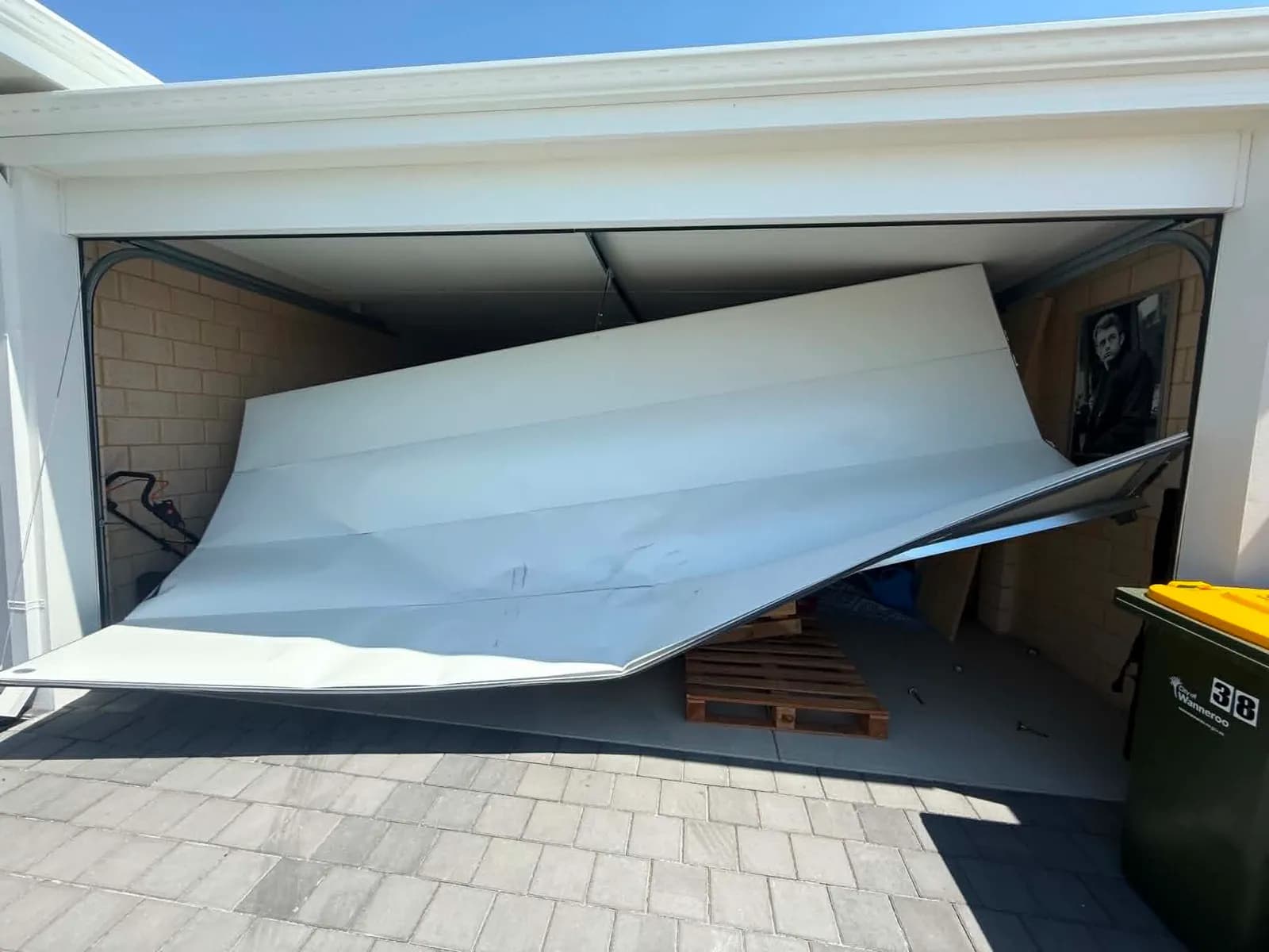 White double sectional garage door collapsed and buckled outward after storm damage in Mandurah White double sectional garage door collapsed and buckled outward after storm damage in Mandurah