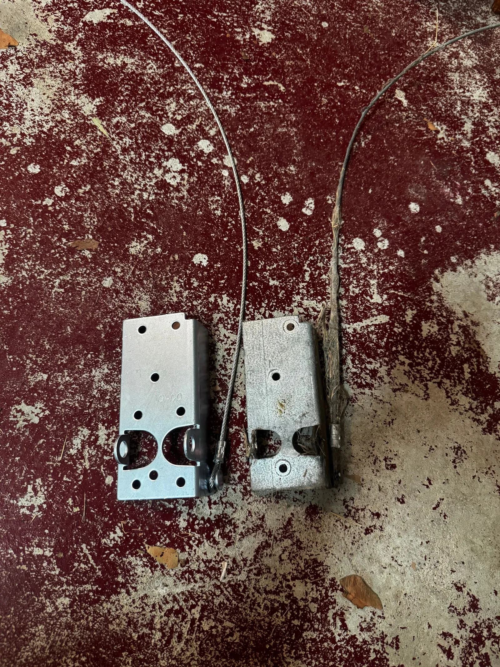 Two old garage door bottom brackets with frayed, snapped lift cables removed from a sectional door in Jane Brook, Perth Two old garage door bottom brackets with frayed, snapped lift cables removed from a sectional door in Jane Brook, Perth